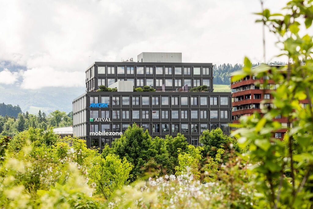 Immeuble de bureaux moderne d'Arval (Suisse) SA à Rotkreuz, entouré d'arbres.